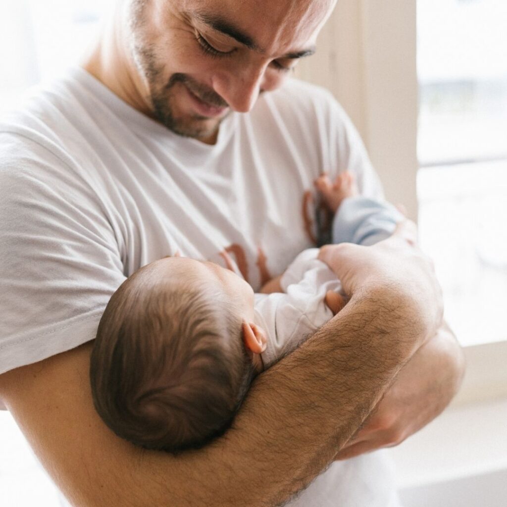 Parent choosing a baby name inspired by a personal hero while holding a newborn child.