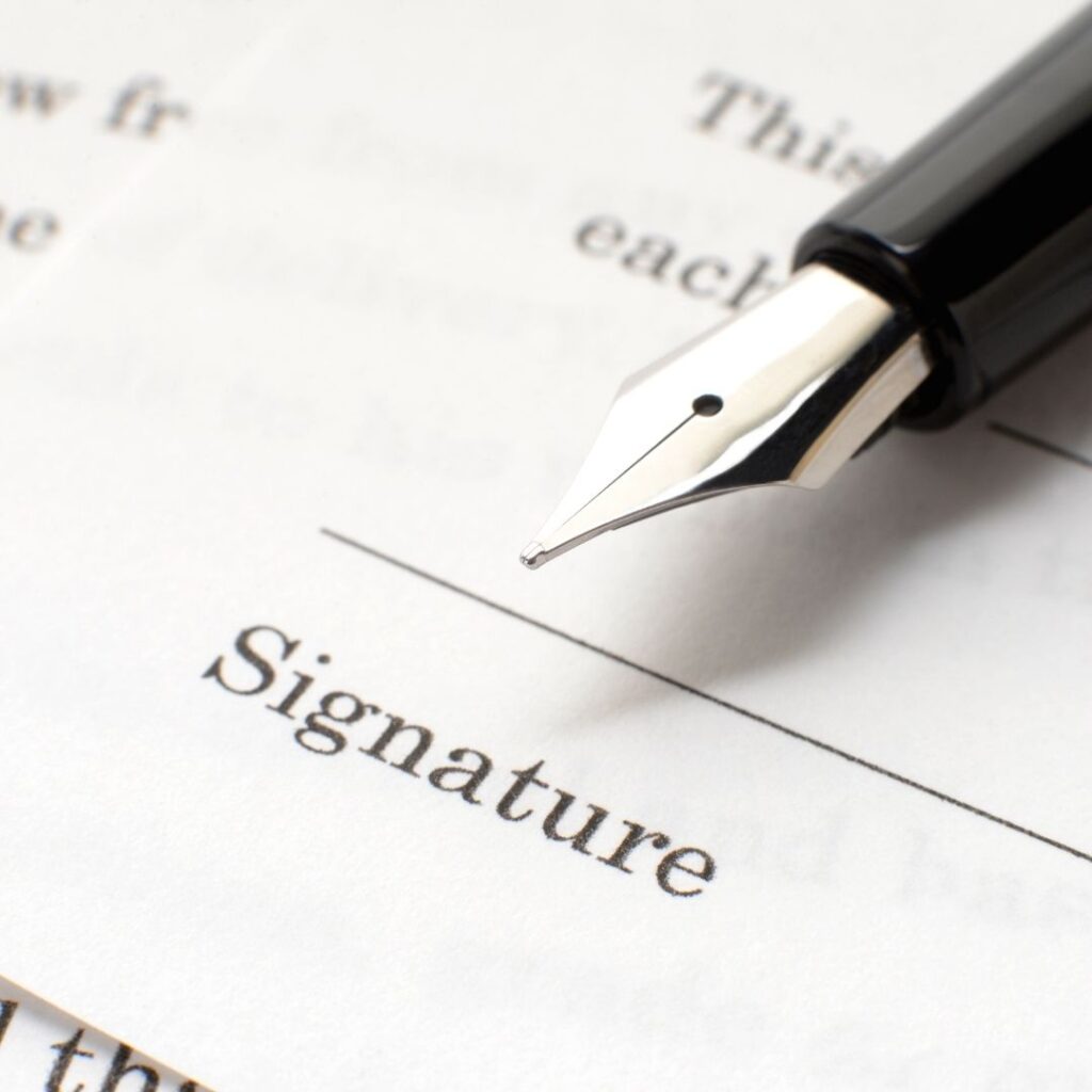 Person signing a deed poll to change the spelling of their name.