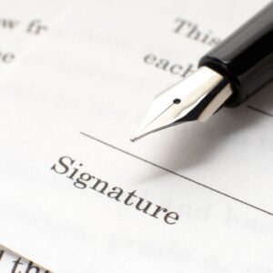 Person signing a deed poll to change the spelling of their name.